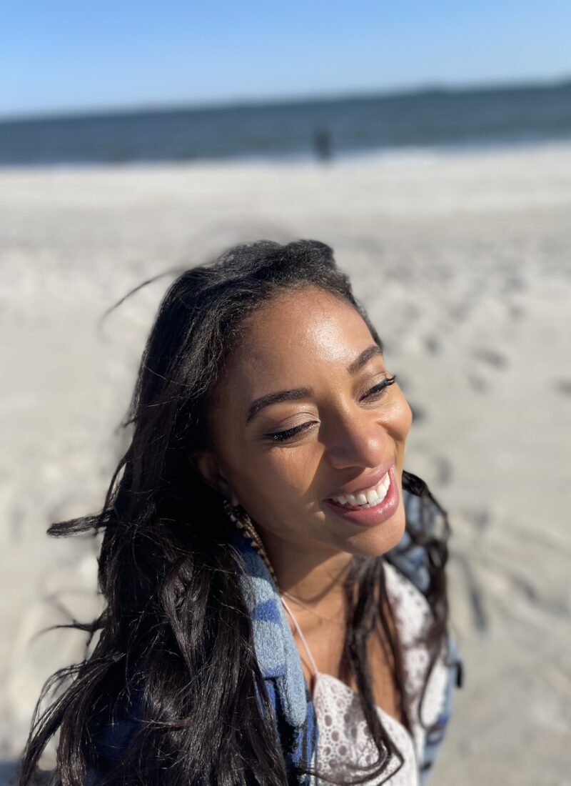 Woman with straight hair smiling on the beach